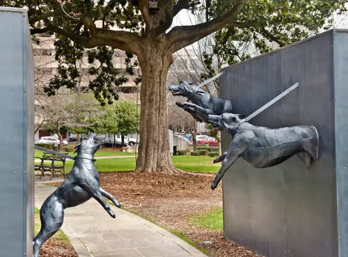 This sculpture depicts three leashed police dogs leaping from walls along the path