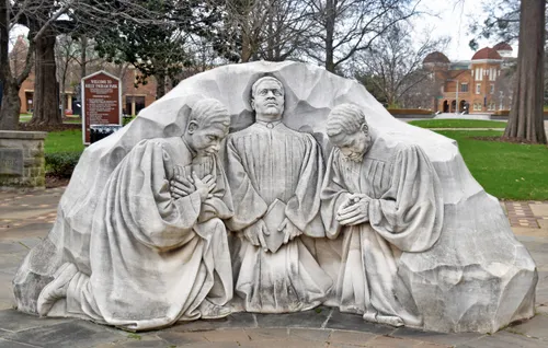 A limestone sculpture by Raymond Kaskey shows three kneeling ministers