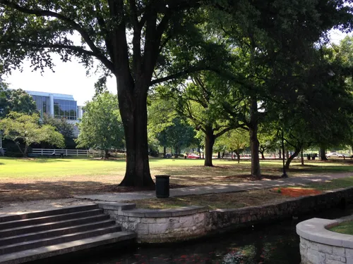 Stone steps in a shady green space lead down to a small canal