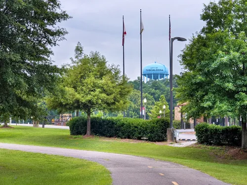 Pathway with flagpoles and blue water tower in the background