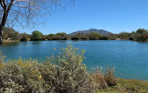 Serene blue waters of Veterans Oasis Lake looking south towards the mountains