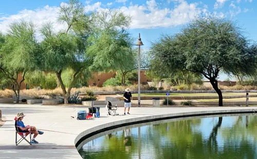 Visitors fishing by the water near Chandler Nature Center