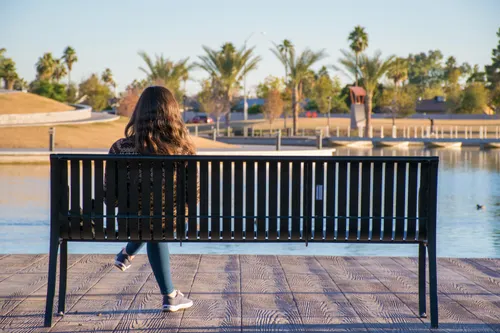 A visitor enjoying the calm evening atmosphere on a park bench