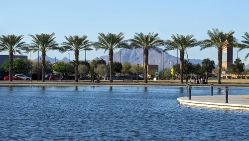 Palm trees line the edge of Riverview Lake with Camelback Mountain visible in the background