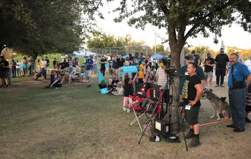 Visitors gathering under trees during a park event