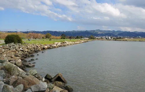 Rocky shoreline along the south shore with park grounds visible to the left