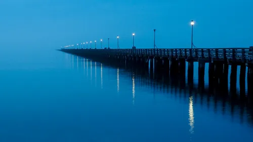 Berkeley Pier stretches into the misty blue waters at twilight