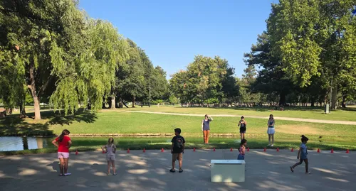 A group of children and their parents enjoy a sunny day at the park
