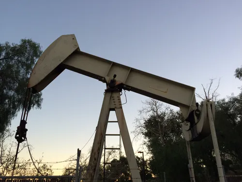 Oil pump jack silhouetted against the twilight sky at the northeast parking lot