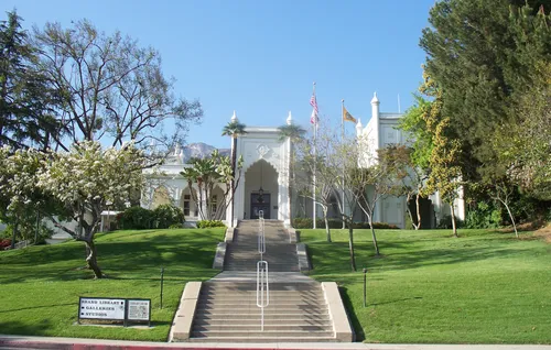 Formal gardens and stairs approaching the Brand Library's white facade