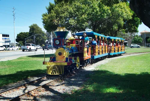 A colorful narrow gauge train travels along the outer edge of Kennedy Park
