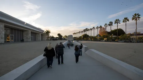 Visitors walk down the long trench toward the Levitated Mass art piece