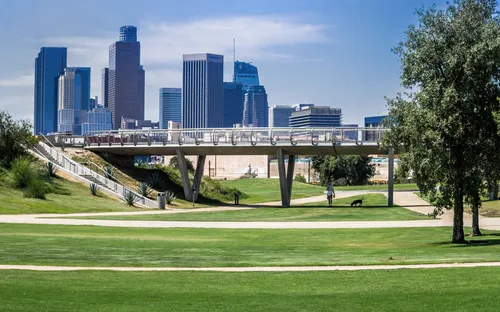 The park's clean lawns with Roundhouse Bridge and Los Angeles skyline behind