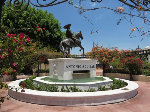 The Antonio Aguilar monument sits at the center of a circular fountain surrounded by flowers