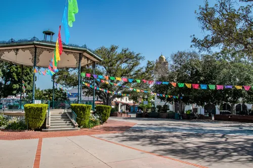 Colorful papel picado flags hang above the brick plaza around the bandstand