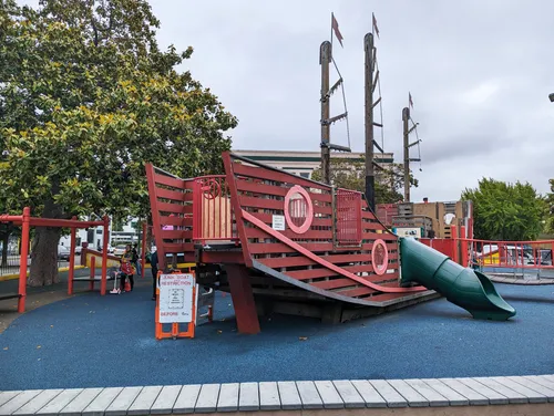 Pirate ship playground structure with blue safety surface