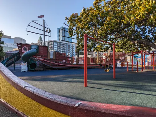 Swings with red poles in the playground area