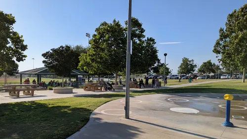 A sunny afternoon at the park with open paths and shaded picnic areas