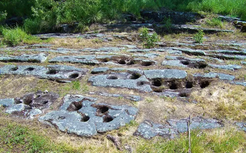 Native American grinding holes carved into the bedrock at the Maidu Museum