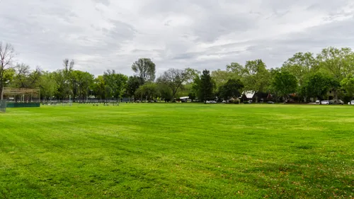 Expansive green lawn stretches across the park's east section