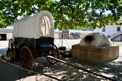 Covered wagon in the shade of trees