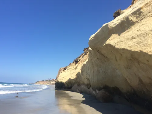 Dramatic sandstone cliffs tower over the shoreline