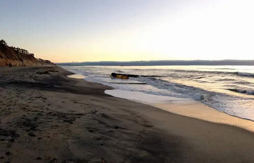 Gentle waves roll onto the sandy beach during golden hour