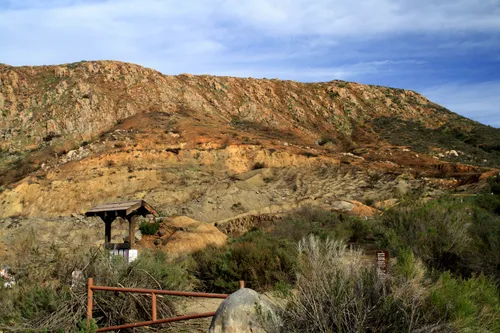 Small trail marker station at the base of the rocky hillside