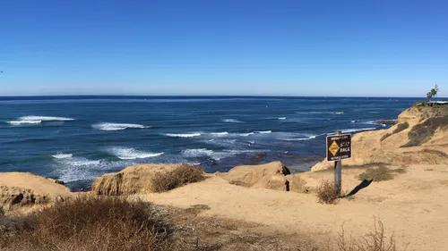 Rugged cliffs overlooking the ocean with waves incoming below