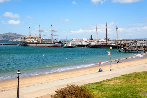 Sandy beach and historic vessels at anchor as seen from the park's waterfront