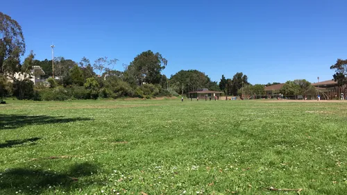 Large flat grass field near the playground