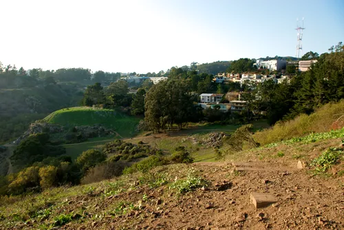 Sloping green hills with Sutro Tower visible in distance