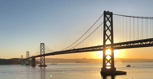 Golden sunset behind Oakland Bay Bridge visible from the park