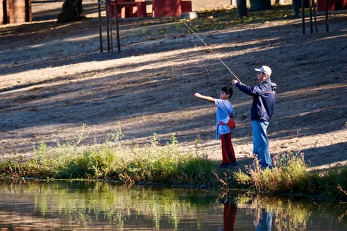 Visitors fishing at the water's edge
