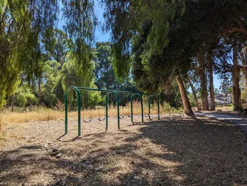 Shaded swing sets tucked among the park's trees