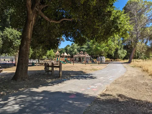 A paved path leads toward the playground area