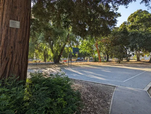 A shaded basketball half court is located in the park's northeast corner