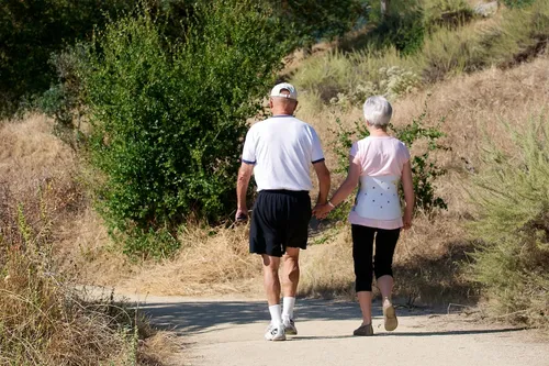 A couple walks a trail through the park's open hillside landscape