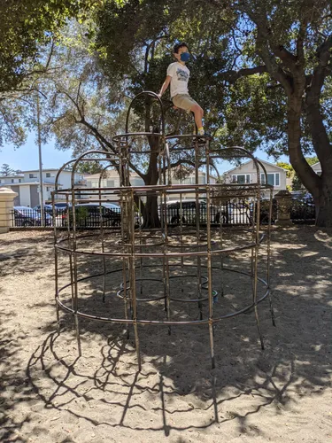 Children's climbing structure in sandy playground area