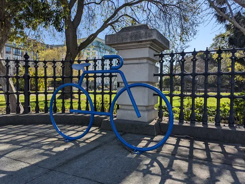Blue bike installation at the park's edge