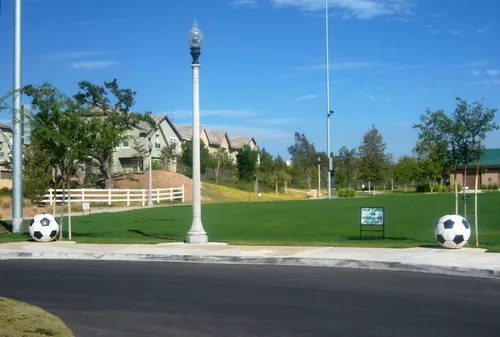 Soccer fields and open green space are on either side of the parking lot