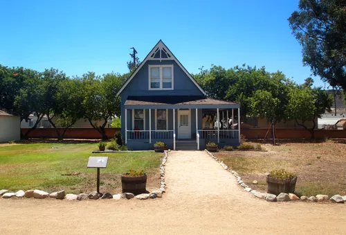 Blue-trimmed historic building with pathway leading to entrance