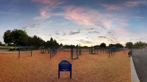Sandy playground area under a colorful evening sky