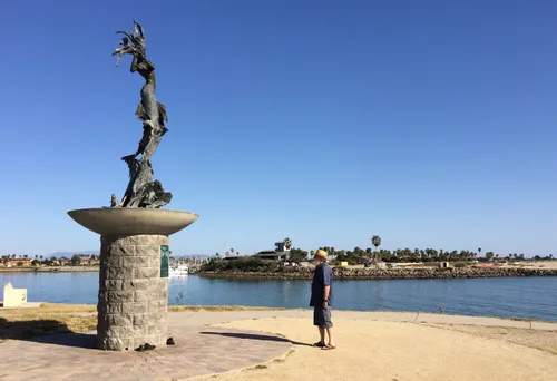A visitor admiring the Russian Mermaid sculpture