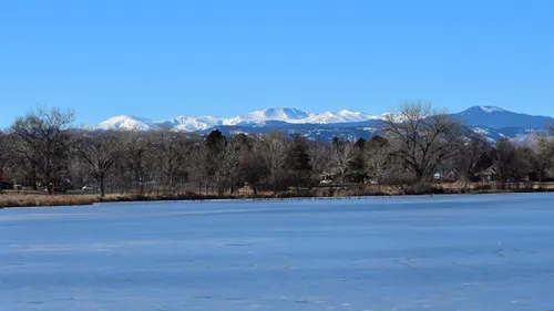 Snow-capped mountains rise beyond the frozen waters of Rocky Mountain Lake
