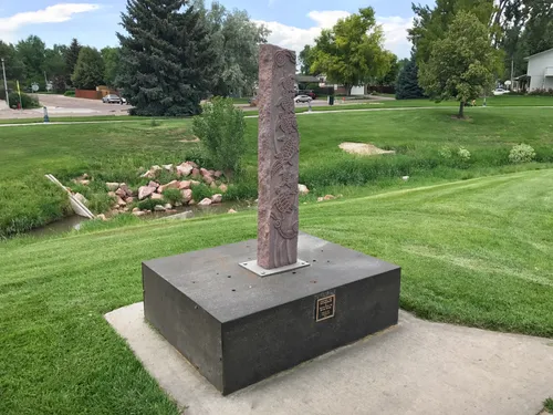 The granite sculpture Leaving the Mothership stands on a pedestal amid green lawns