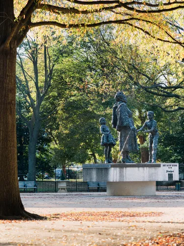 Bronze statues silhouetted against autumn trees in Lincoln Park