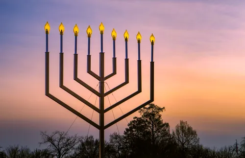 The National Menorah lit against a colorful evening sky