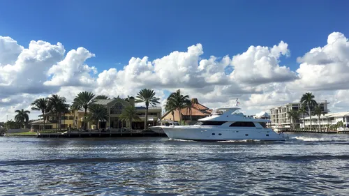 Luxury yacht passing waterfront homes