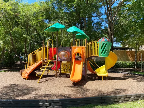 Colorful playground equipment under tropical trees